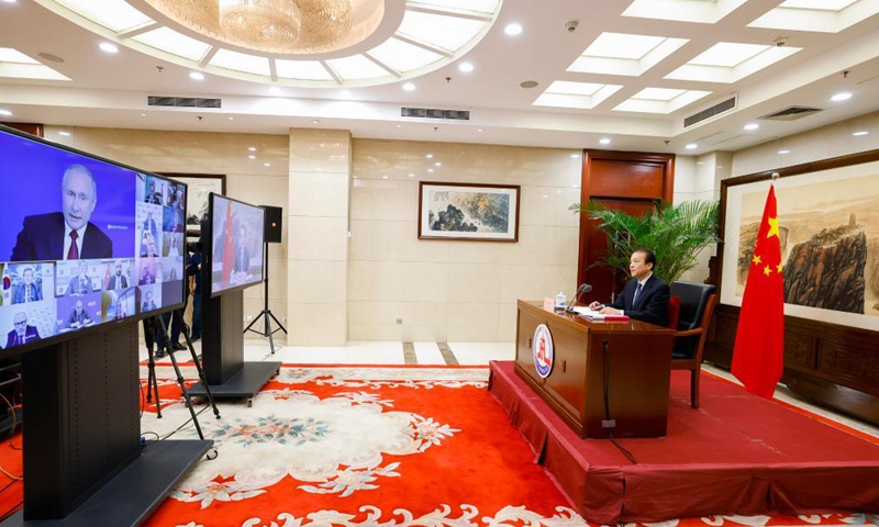 Russian President Vladimir Putin (on screen) answers a question from He Ping (R), president and editor-in-chief of Xinhua News Agency, on China-Russia relations, in a meeting with heads of major international news agencies held in St. Petersburg on Friday local time.Photo:Xinhua