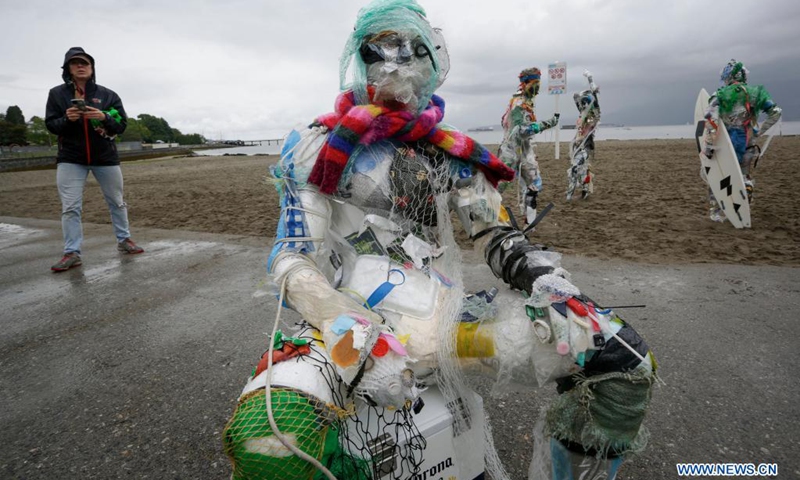 Figures made with plastics removed from shorelines are displayed at Kitsilano Beach in Vancouver, British Columbia, Canada, on June 6, 2021. Created by multidisciplinary artist Caitlin Doherty and made with plastics removed from Canadian shorelines, a set of figures named plastic beachgoers embody people's collective contribution to plastic pollution, bring the topic of shoreline pollution to the forefront.(Photo: Xinhua)
