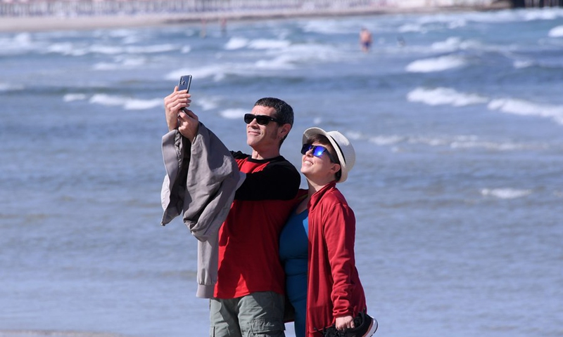 People take a selfie on a beach in Cagliari, Sardinia, Italy, on May 28, 2021.(Photo: Xinhua)