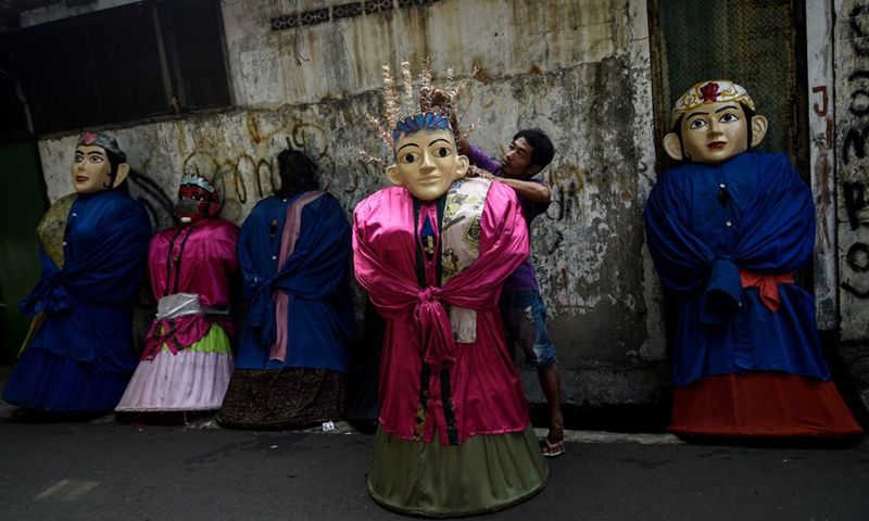A worker holds a traditional Ondel-Ondel in Jakarta, Indonesia, June 7, 2021.(Photo: Xinhua)