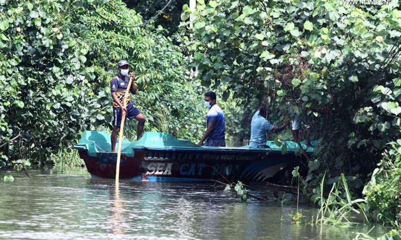People row a boat to distribute food to flood-trapped villagers on the outskirts of Colombo, Sri Lanka, on June 5, 2021. The death toll from Sri Lanka's inclement weather conditions rose to 10 Saturday evening while 219,027 people were affected, the country's Disaster Management Center said.(Photo: Xinhua)
