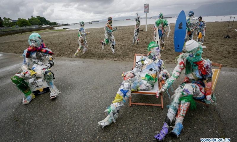 Figures made with plastics removed from shorelines are displayed at Kitsilano Beach in Vancouver, British Columbia, Canada, on June 6, 2021. Created by multidisciplinary artist Caitlin Doherty and made with plastics removed from Canadian shorelines, a set of figures named plastic beachgoers embody people's collective contribution to plastic pollution, bring the topic of shoreline pollution to the forefront.(Photo: Xinhua)