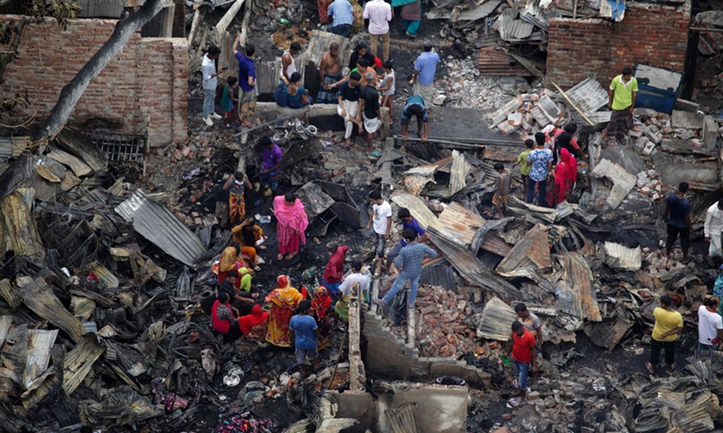 Slum dwellers search for their belongings from ashes after a massive fire in a slum in Bangladeshi capital Dhaka, on June 7, 2021.(Photo: Xinhua)