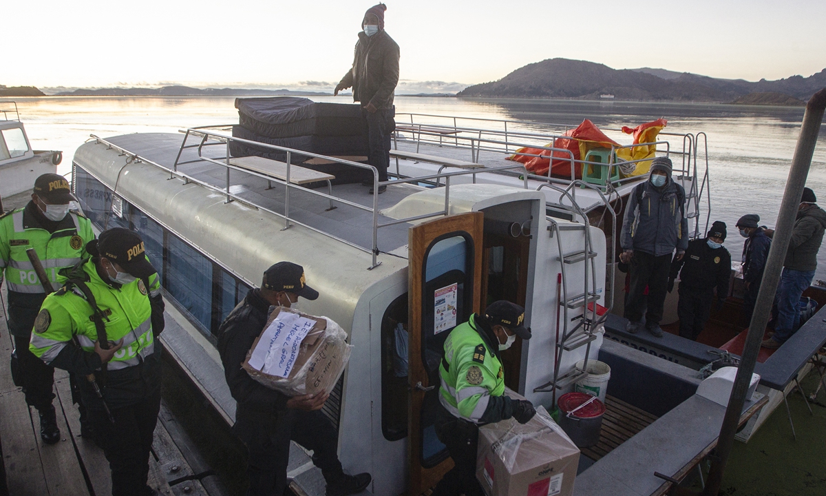 Policemen load electoral material on a ferry to be transported to voting stations of Taquile and Amantani islands at Puno port, Peru on Saturday. Photo: AFP