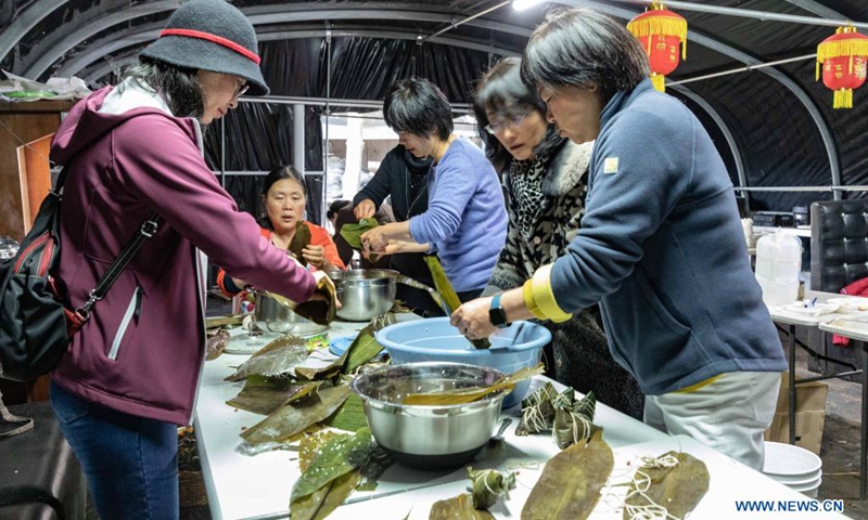 People make zongzi to celebrate the Dragon Boat Festival in Canberra, Australia, on June 6, 2021. Zongzi is a traditional Chinese delicacy made of rice and stuffing wrapped in reed or bamboo leaves, usually consumed on the occasion of Dragon Boat Festival, which falls on June 14 this year.(Photo: Xinhua)