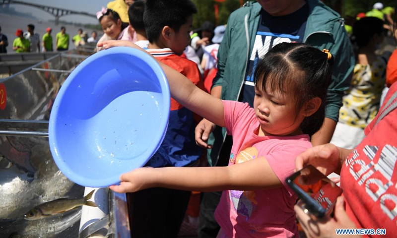 People release fish fry at Juzizhou Park in Changsha, central China's Hunan Province, June 6, 2021. About 80.32 million fish fry were released into the Xiangjiang River in Changsha on Sunday. June 6 has been observed in China as the national fish releasing day to help promote ecological awareness.(Photo: Xinhua)