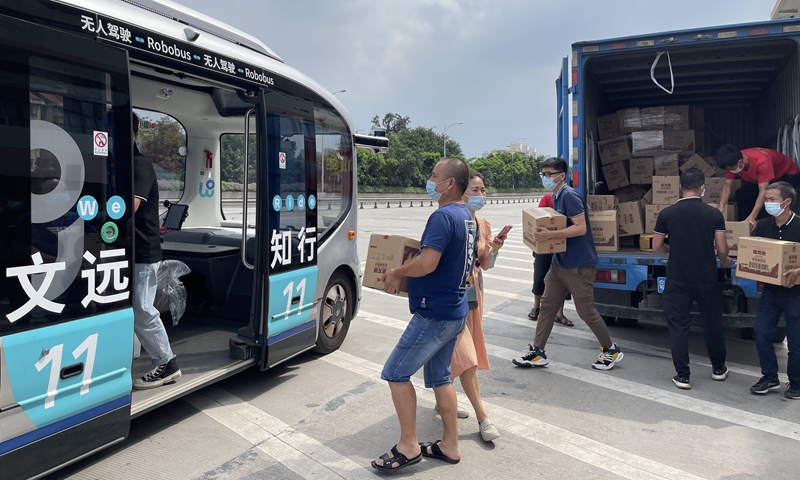 Volunteers in Guangzhou, Guangdong Province, helps load anti-virus material on WeRide's autonomous minibus on June 5. Photo: Courtesy of WeRide  