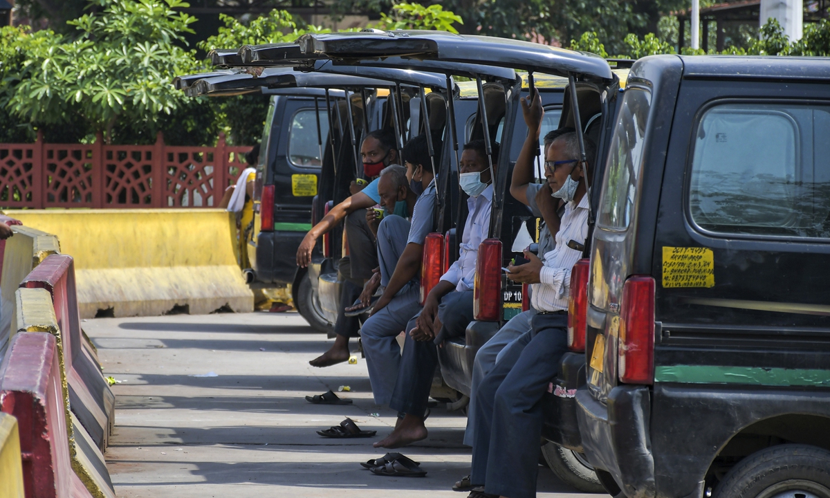 Taxi drivers wait for passengers outside the New Delhi railway station in New Delhi, India, on Monday. Businesses in two of India's largest cities are reopening as part of a phased easing of lockdown measures in several states now that the number of new coronavirus infections in the country is on a steady decline. Photo: AP