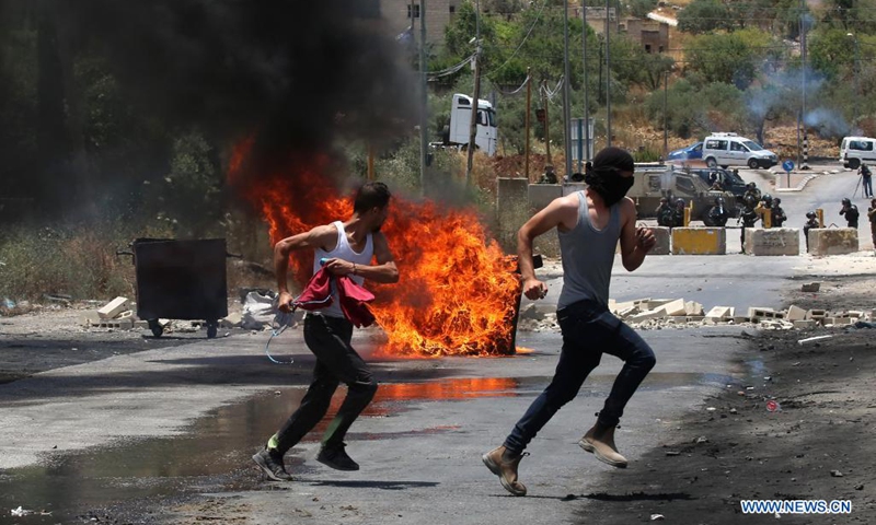 Palestinian protesters run to take cover during a protest against the expanding of Jewish settlements and the Israeli annexation plan in the village of Beita, south of the West Bank city of Nablus, on June 8, 2021.(Photo: Xinhua)