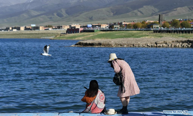 Tourists enjoy themselves at the Erlangjian scenic spot of Qinghai Lake in northwest China's Qinghai Province, June 4, 2021. Located in the northeastern part of the Qinghai-Tibet Plateau, the Qinghai Lake is key to maintaining the ecological balance in western China. It is also a natural barrier for controlling the eastward spread of desertification and ensuring the safety of agricultural areas in eastern China.(Photo: Xinhua)