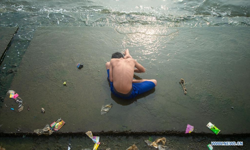 A boy plays on the seaside at Muara Angke fishing village of North Jakarta, Indonesia, June 8, 2021. June 8 marks World Oceans Day. This year's theme is The Ocean: Life and Livelihoods. (Photo by Veri Sanovri/Xinhua)