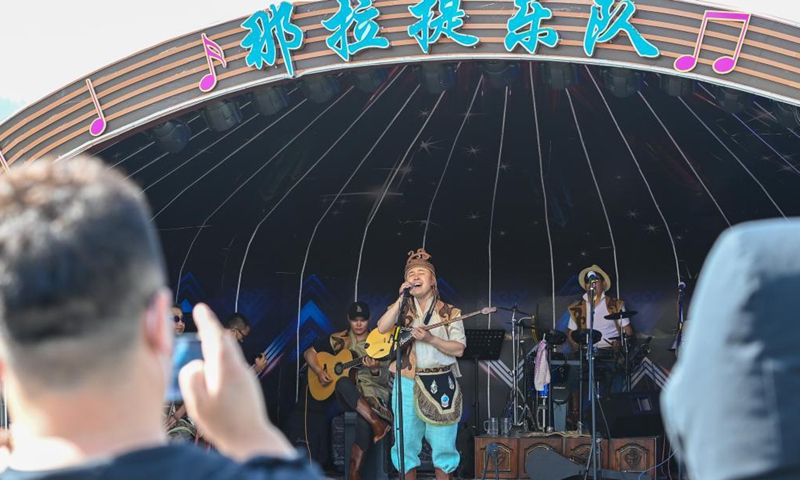 Visitors enjoy the performance of Narat band at the Narat scenery spot in Xinyuan County of northwest China's Xinjiang Uygur Autonomous Region, June 3, 2021. Photo: Xinhua