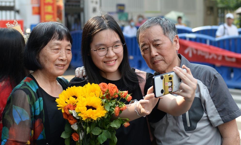 An examinee poses for photo with families outside an exam site at a middle school in Changsha, capital of central China's Hunan Province, June 9, 2021. China's annual college entrance exam concluded on Tuesday in some parts of the country. Photo: Xinhua