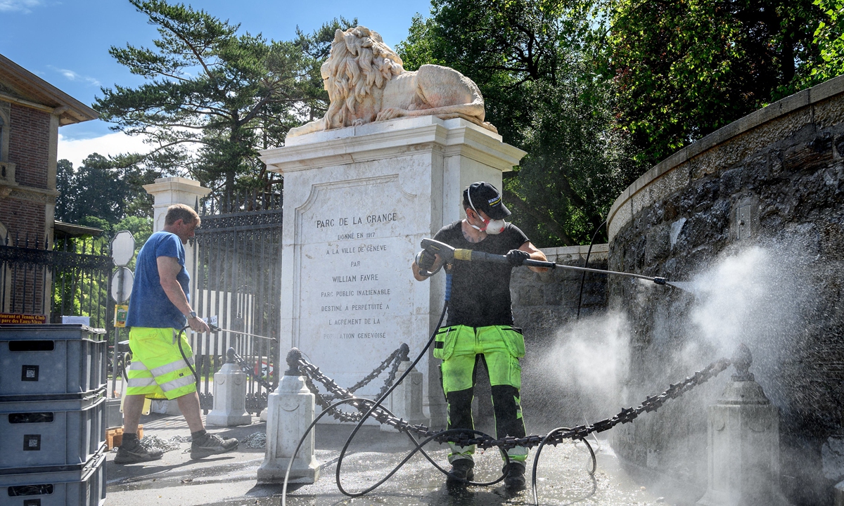 A man uses a pressure washer on Tuesday to clean the low wall surrounding the 