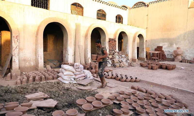 A worker carries dried potteries at a workshop in Fustat Pottery City in Cairo, Egypt, June 8, 2021.Photo: Xinhua