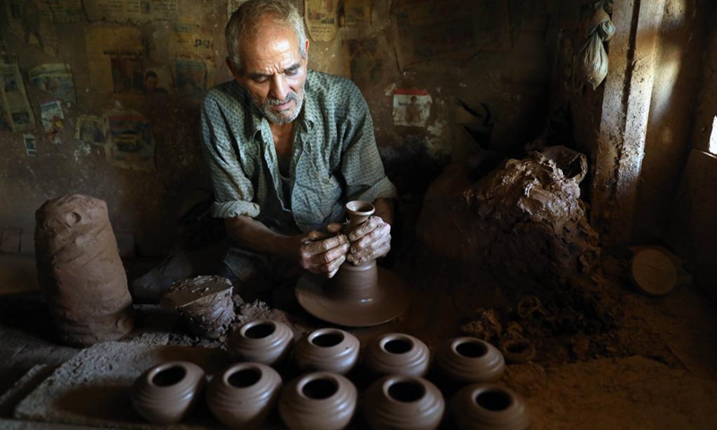 A worker makes pottery at a workshop in Fustat Pottery City in Cairo, Egypt, June 8, 2021. Fustat Pottery City is a pottery making and selling place where you can find a broad range of unique pottery items. Pottery workshop owners here now suffer from stagnation in business due to the COVID-19 pandemic.Photo: Xinhua