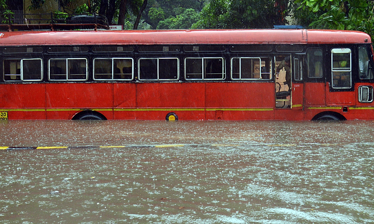 A driver looks out from inside a bus stuck in floodwaters during a heavy monsoon that arrived two days ahead of its normal date in Mumbai on Wednesday. The India Meteorogical Department issued a red alert for Mumbai, Thane, Palghar and Raigad, which signifies the possibility of 