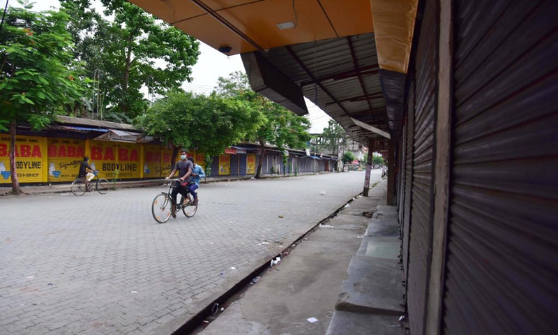 A man wearing a face mask rides a bicycle in a closed market during a lockdown imposed to curb the spread of the COVID-19 in Nagaon district of Assam, India, June 8, 2021.Photo: Xinhua