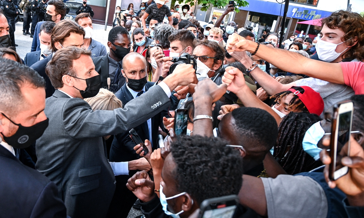 French President Emmanuel Macron (left) interacts with members of a crowd while visiting Valence on Tuesday during a visit in the French southeastern department of Drome, the second stage of a nationwide tour ahead of 2022's presidential election. Photo: AFP
