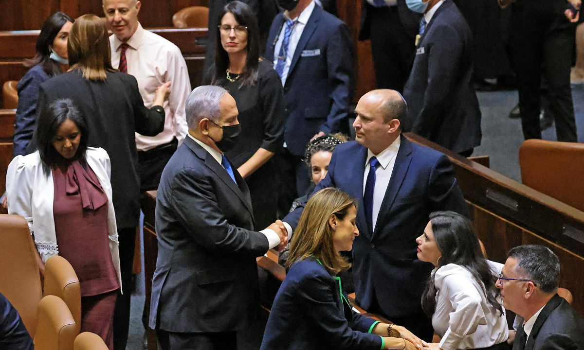 Israel's outgoing prime minister Benjamin Netanyahu (middle left) shakes hands with his successor Naftali Bennett, after a special session to vote on a new government at the Knesset in Jerusalem on Sunday. Photo: VCG
