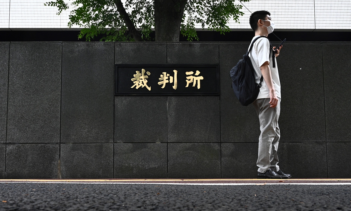 A man walks past the main gate of the Tokyo district court where former US special forces member Michael Taylor and his son Peter, who allegedly staged the operation to help fly former Nissan chief Carlos Ghosn out of Japan in 2019, arrived at the court in Tokyo on Monday. Photo: AFP