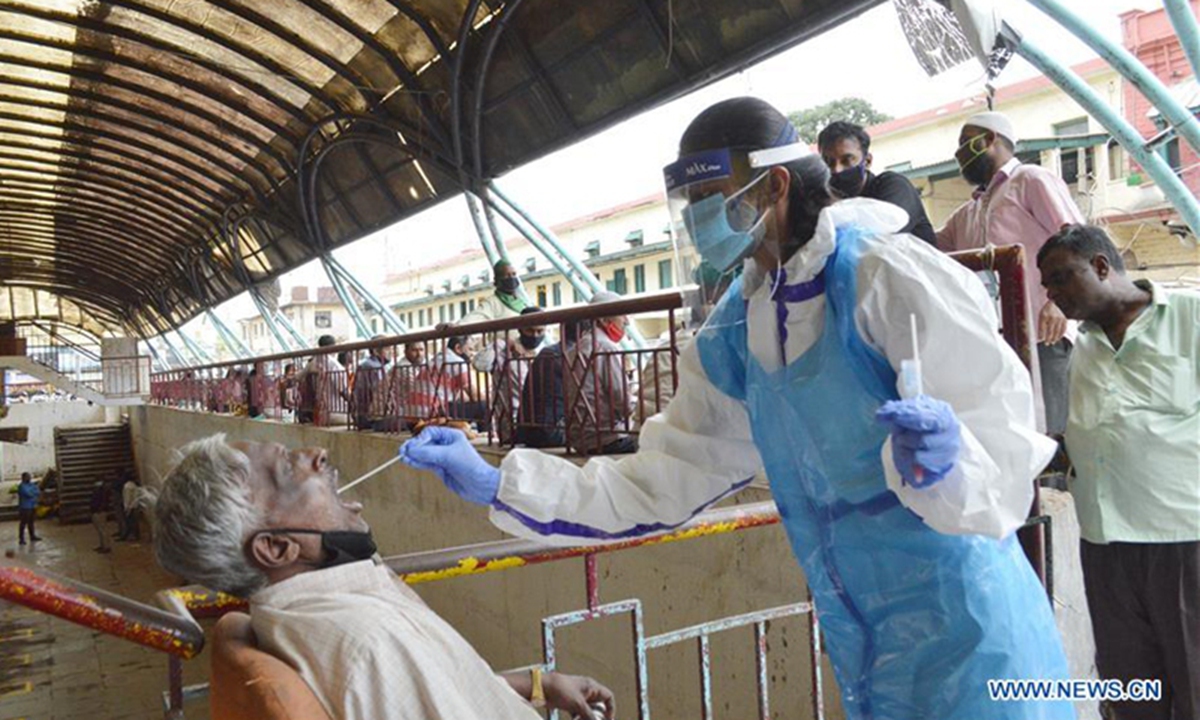 An Indian health worker takes swab tests of a man. Photo: Xinhua