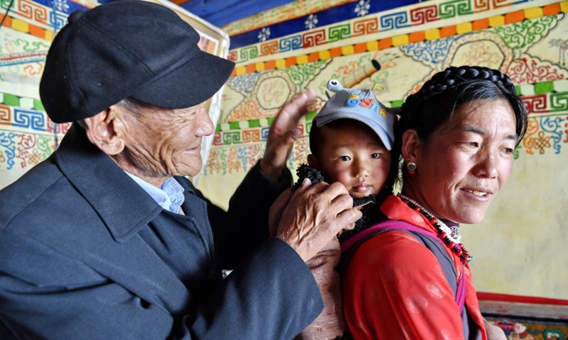Migmar (L) is seen with his family members in Lhaya Village, Gyamco Township, Namling County of Xigaze City, southwest China's Tibet Autonomous Region, April 18, 2021. Photo: Xinhua