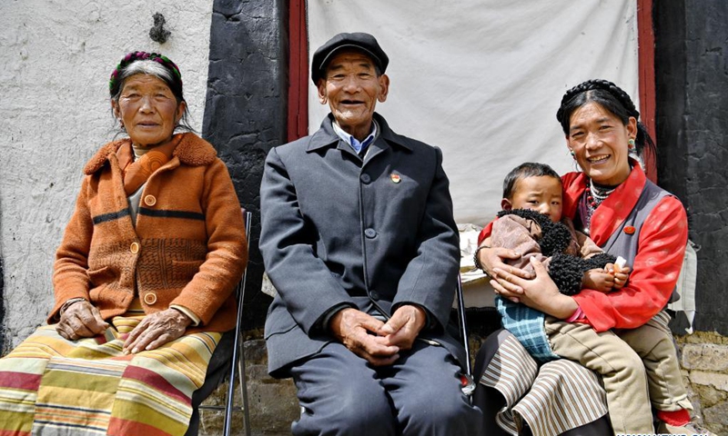 Migmar (C) poses for a group photo with his wife (1st L), daughter (1st R) and his grandson in front of his residence in Lhaya Village, Gyamco Township, Namling County of Xigaze City, southwest China's Tibet Autonomous Region, April 18, 2021.Photo: Xinhua