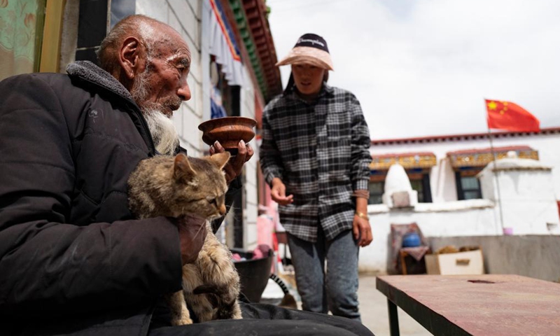Tobgye and his granddaughter are seen at home in Bomdoi Township, Dagze District of Lhasa, southwest China's Tibet Autonomous Region, April 25, 2021.The old time was heaven for the aristocrats, but hell for the poor, Tobgye recalled. In those days, the serfs wore worn-out clothes, which were rough in texture. Life changed after the democratic reform. Tobgye was provided with land, live stocks and houses, and has enjoyed a happy life ever since. Photo: Xinhua 