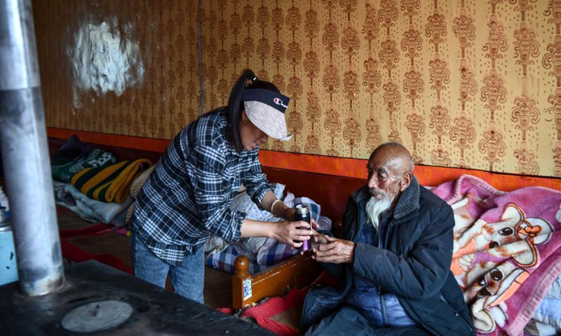 The granddaughter of Tobgye serves a cup of tea to Tobgye in Bomdoi Township, Dagze District of Lhasa, southwest China's Tibet Autonomous Region, April 25, 2021.Photo: Xinhua 