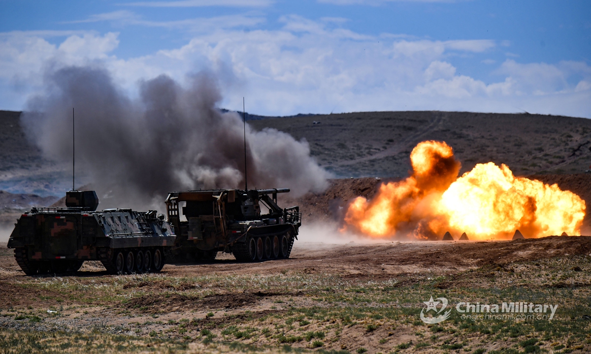 An assault breacher vehicle fires obstacle-breaching shells to clear obstacles in the way during a barrier-breaking training exercise at a comprehensive military training base on June 5, 2021. This training exercise was jointly conducted by a chemical defense detachment and an engineering detachment under the PLA 73rd Group Army. (eng.chinamil.com.cn/Photo by Liu Zhiyong)