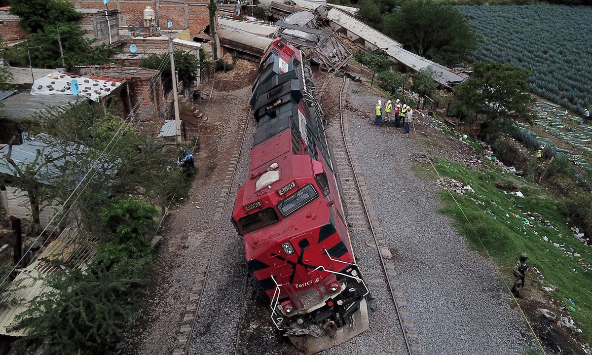 View of a train that derailed while transporting grains and seeds in 118 wagons, in the community of San Isidro Mazatepec in Tala, State of Jalisco, Mexico, on Tuesday. A freight train derailed and toppled onto houses alongside the tracks in western Mexico on Tuesday, killing one resident and injuring three others, emergency services said. Photo: AFP