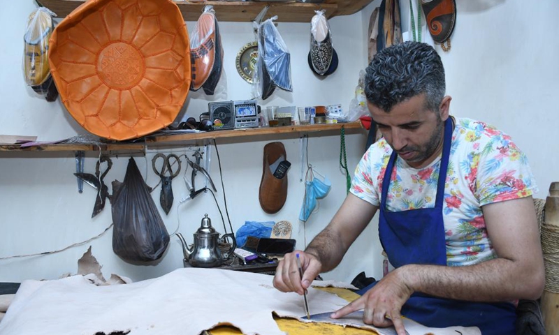 A craftsman makes Moroccan traditional leather slippers in Marrakech, Morocco, June 15, 2021. (Photo by Chadi/Xinhua)