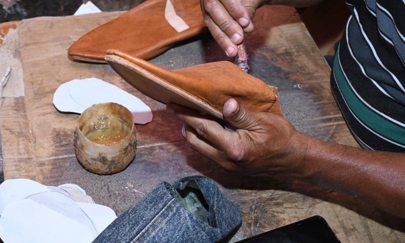 A craftsman makes Moroccan traditional leather slippers in Marrakech, Morocco, June 15, 2021. (Photo by Chadi/Xinhua)