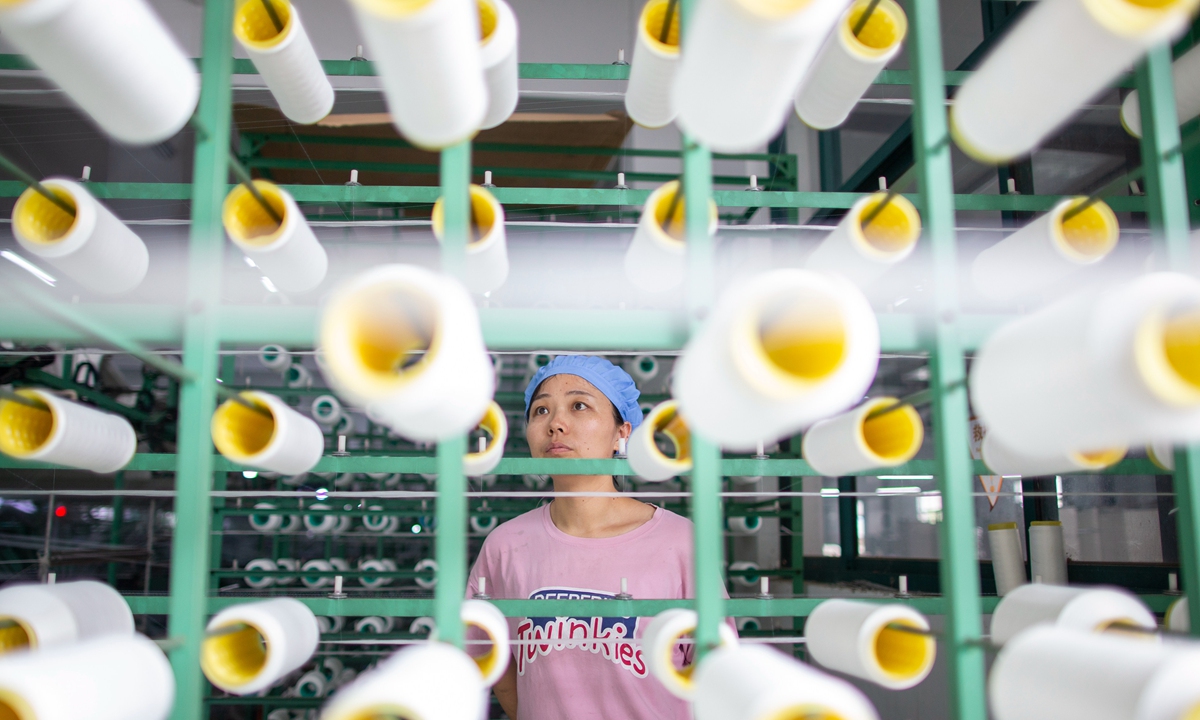 A worker works on orders for nylon products at the Jinyu textile firm in Nantong, East China's Jiangsu Province on Wednesday. From January to April, Nantong's foreign trade totaled 94.52 billion yuan ($14.78 billion), a year-on-year increase of 23.1 percent, with exports up by 24 percent. Photo: cnsphoto

