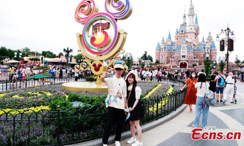 Visitors take photos in front of the Enchanted Storybook Castle at Shanghai Disney Resort, June 16, 2021.(Photo/ Tang Yanjun)
