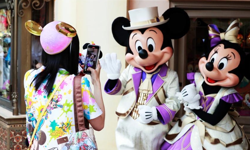 A visitor interacts with Mickey and Minnie at Shanghai Disney Resort, June 16, 2021. (Photo/ Tang Yanjun)
