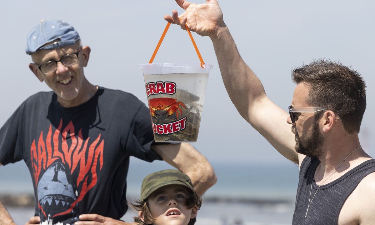 A man holds up a bucket with crabs in it at the tidal pool on June 2 in Margate. Photo: VCG