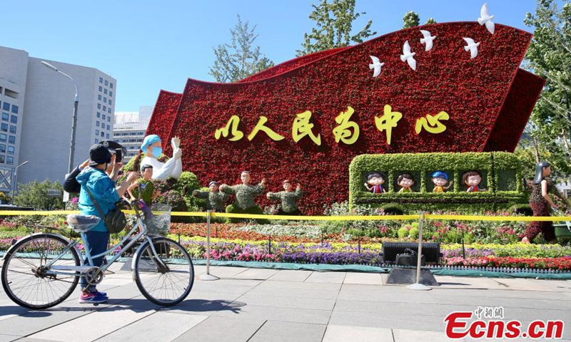Passengers take photos with themed flowerbeds at the Xidan intersection along Chang'an Avenue in Beijing, June 17, 2021. Many themed flowerbeds were displayed along Chang'an Avenue to celebrate the centennial of the CPC. Photo: China News Service