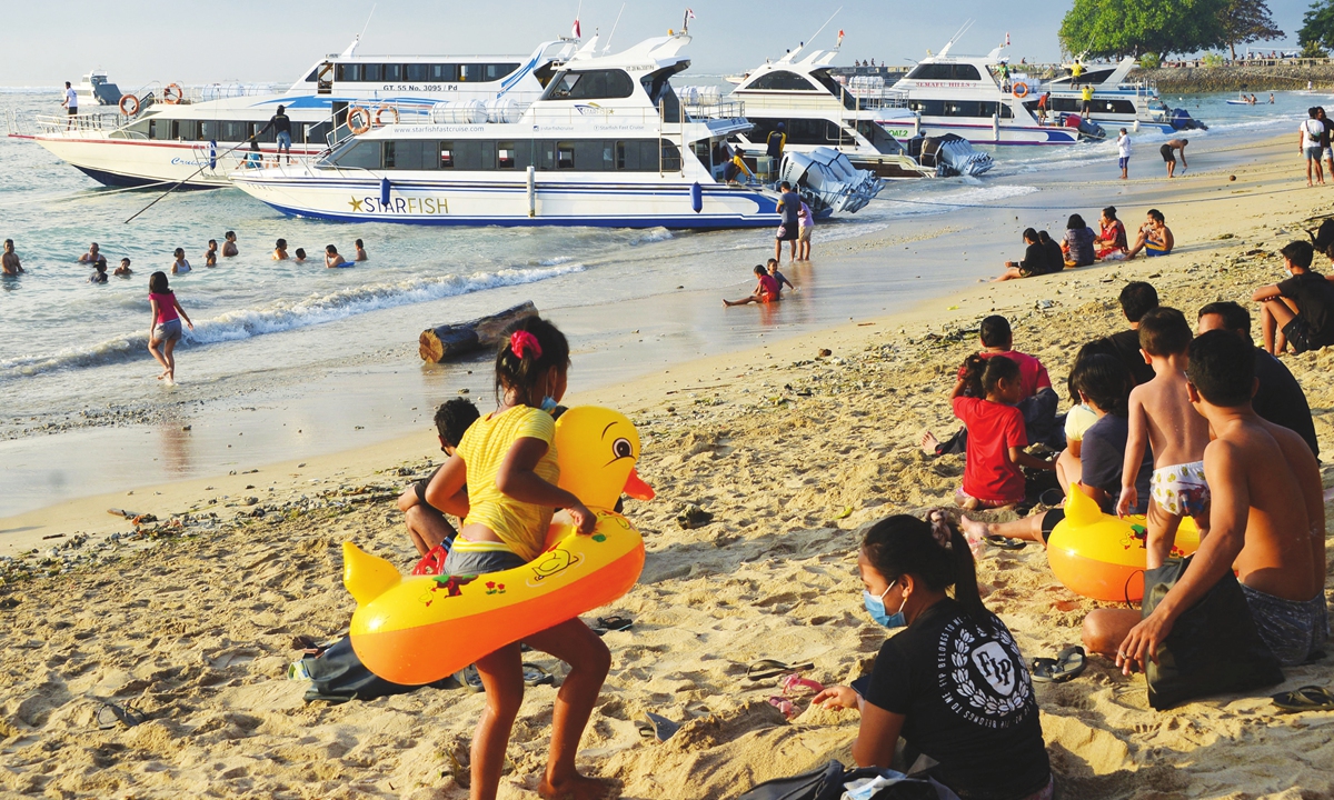 Local residents enjoy an early morning swim along Sanur beach as boats line up to prepare to load passengers to cross to the nearby tourist island of Nusa Penida, on Indonesia’s resort island of Bali on Sunday. Photo: AFP