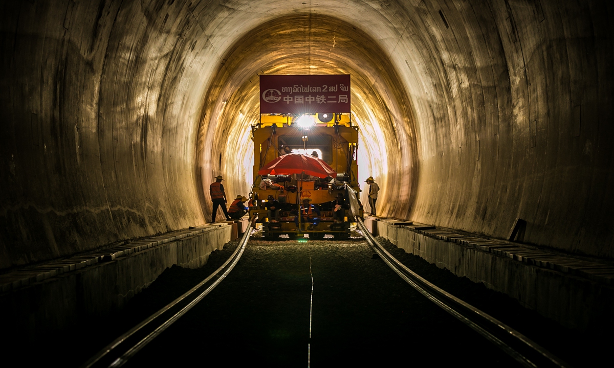 Workers from China and Laos work together to lay the track for the first tunnel of the Lao-China Railway at the construction site in Vientiane on May 23, 2020. Photo: Xinhua