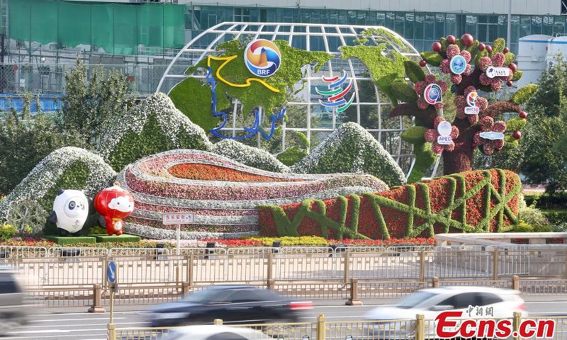 A passenger takes photos with themed flowerbeds at the Dongdan intersection along Chang'an Avenue in Beijing, June 17, 2021.  Photo: China News Service