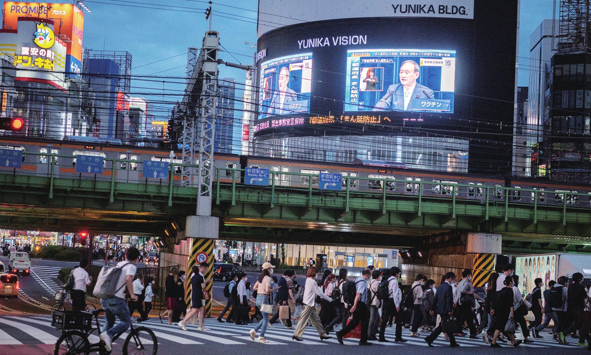 Japan's Prime Minister Yoshihide Suga is seen on a live TV broadcast in Tokyo's Shinjuku area on Thursday, after Japan announced that a virus state of emergency in Tokyo and several other regions will be lifted on June 20. Photo: AFP