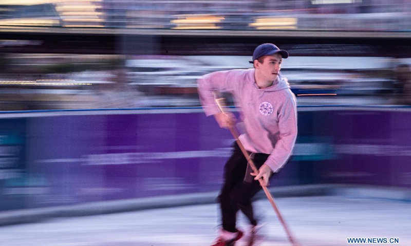 A man plays ice hockey on the Winter Festival at Darling Harbour in Sydney, Australia, on June 18, 2021.Photo:Xinhua