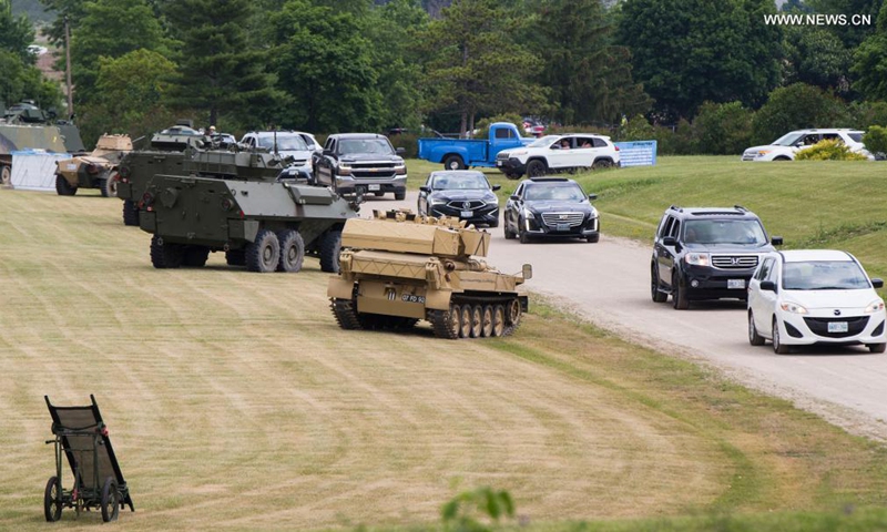 People drive their vehicles to attend the 2021 Mega Wheels Drive-Thru event in Milton, Ontario, Canada, on June 20, 2021. The drive-thru event, held from June 18 to 27, features monster trucks, classic cars, military vehicles and more through a 2.5 km course.(Photo: Xinhua)