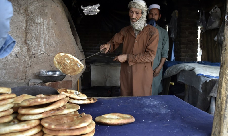 An Afghan refugee man prepares Afghani bread on the eve of the World Refugee Day on the outskirts of Peshawar, Pakistan, on June 19, 2021.(Photo: Xinhua)