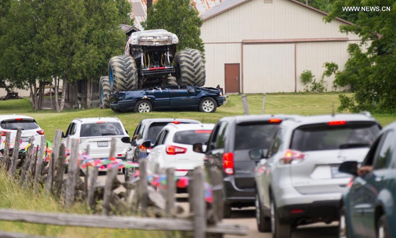 People drive their vehicles to attend the 2021 Mega Wheels Drive-Thru event in Milton, Ontario, Canada, on June 20, 2021. The drive-thru event, held from June 18 to 27, features monster trucks, classic cars, military vehicles and more through a 2.5 km course.(Photo: Xinhua)