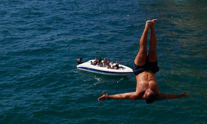 A man jumps into the sea at Raouche in Beirut, Lebanon, on June 20, 2021. Lebanon has witnessed over the past month a remarkable drop in the number of new COVID-19 infections.(Photo: Xinhua)