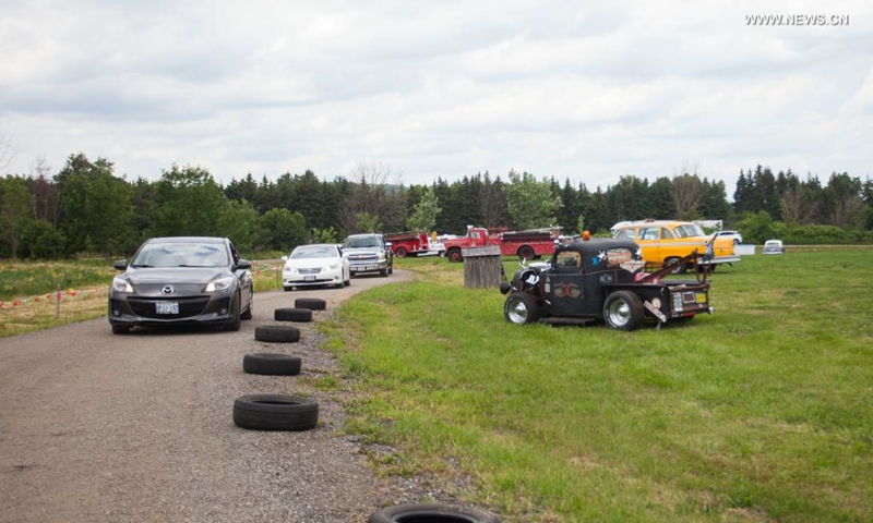 People drive their vehicles to attend the 2021 Mega Wheels Drive-Thru event in Milton, Ontario, Canada, on June 20, 2021. The drive-thru event, held from June 18 to 27, features monster trucks, classic cars, military vehicles and more through a 2.5 km course.(Photo: Xinhua)