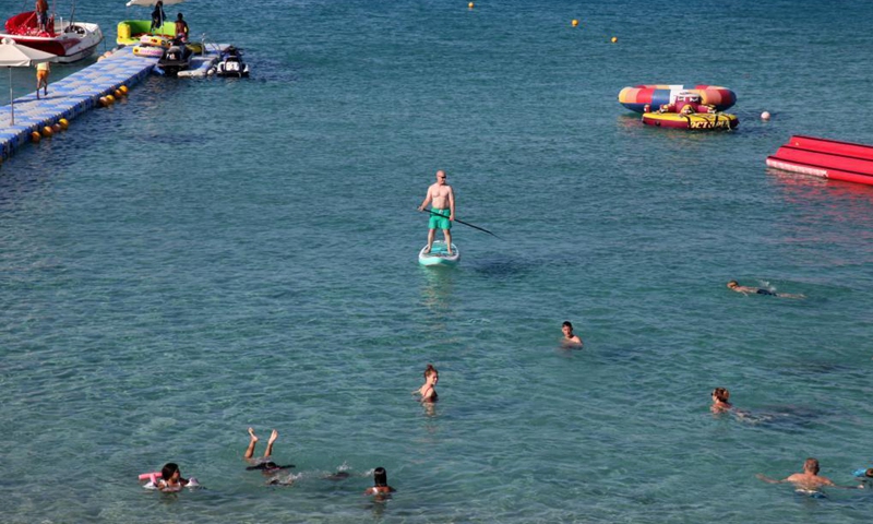 People enjoy themselves at the seaside in Protaras, Cyprus, on June 20, 2021. Most of the COVID-19 restrictions have been lifted in Cyprus.(Photo: Xinhua)